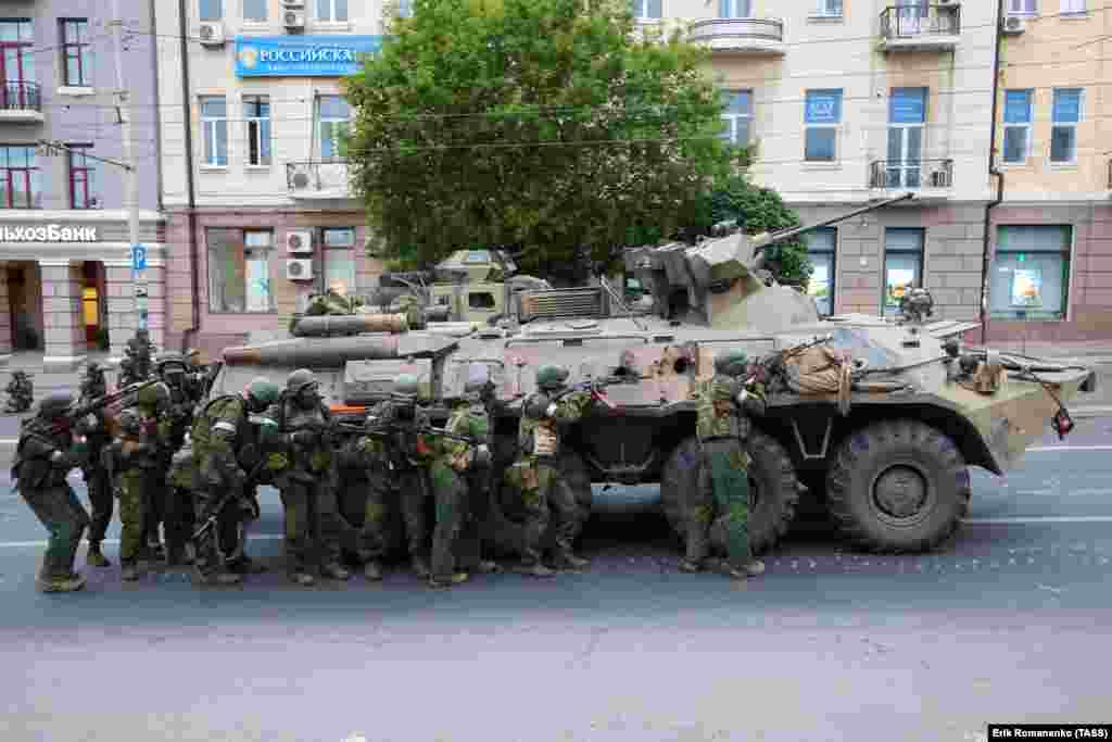 Armed men alongside an armored vehicle in the center of Rostov-on-Don. The photo was made on the morning of June 24, near Russia's southern military district headquarters. 