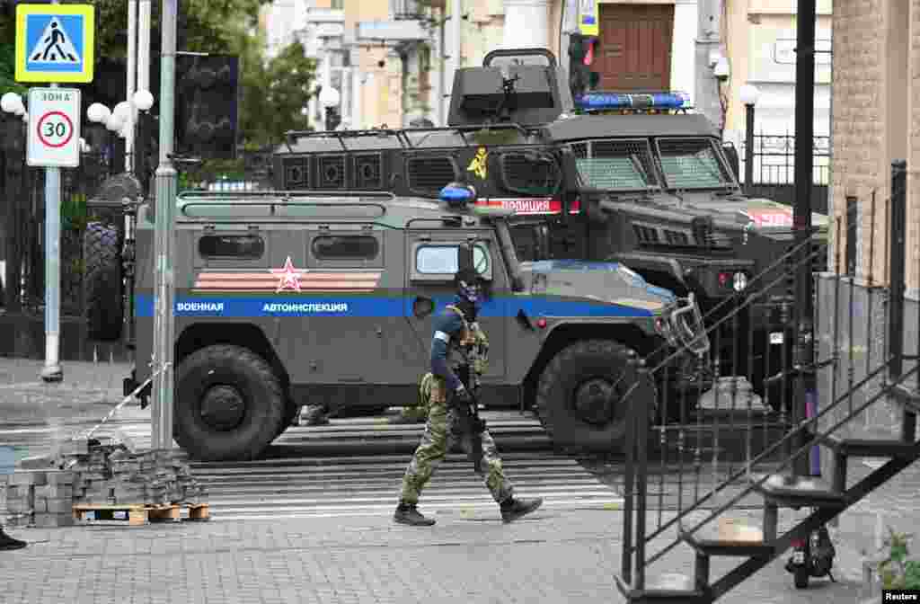 A Wagner fighter seen in front of armored vehicles reportedly belonging to the Russian military in Rostov-on-Don. 