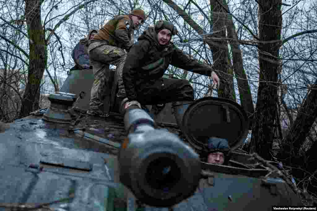 Ukrainian soldiers board 2S1 Gvozdika self-propelled howitzer before it moves into a firing position.  