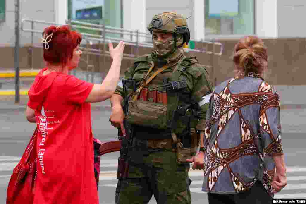 A woman speaks to an armed man in Rostov-on-Don after exiting a bus.   