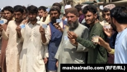 په کراچۍ کې افغان کډوال د استوګنې اسناد خبریالانو ته ښیې ـ پخوانی انځور.