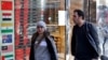 People walk past a currency exchange shop in Tehran. UN snapback sanctions are expected to hit the Iranian economy, including the value of the country's currency, the rial.
