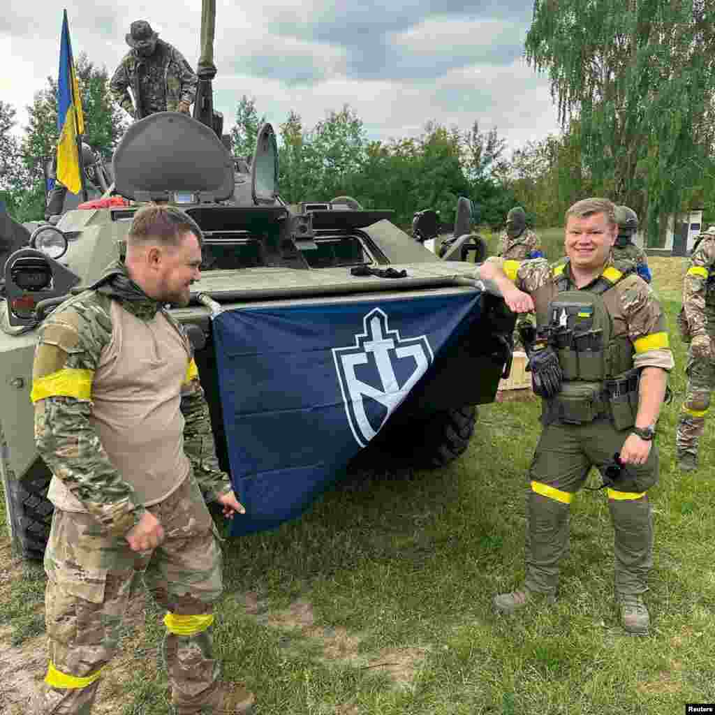 Members of the Russian Volunteer Corps display their flag in an image apparently taken inside Russian territory that was released on May 23.  Michael Colborne, a journalist with the open-source investigative group Bellingcat, told Vice News that he immediately recognized some of the men allegedly involved in the raid as well-known neo-Nazis. "These are people who have literally organized Hitler worship nights, written poems about Hitler, and lead bands whose names and songs are about Hitler," he said.