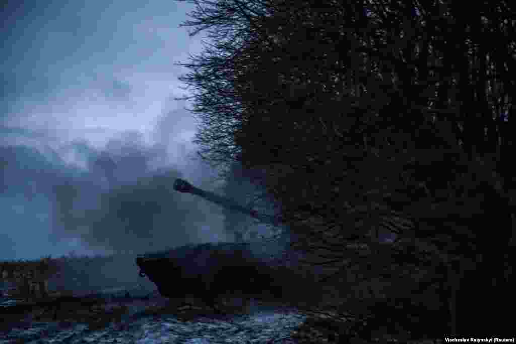 A cloud of smoke emanates from the gun after a shell is launched toward Russian positions.  