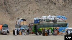 له کوټې څخه بهر یوشمېر مسافر وړونکي ګاډي ولاړ دي - پخوانی انځور.