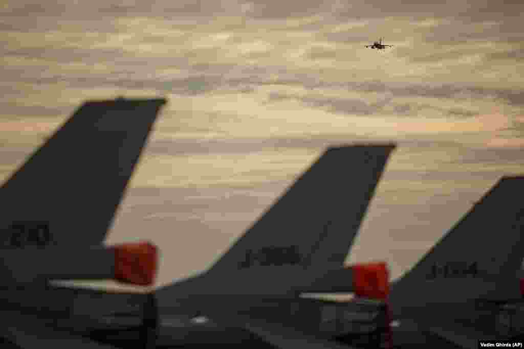 Винищувач F-16 ПС Румунії пролітає над авіабазою. Румунія, яка є членом НАТО з 2004 року, збільшила витрати на оборону, тоді як НАТО посилило свою присутність на східному фланзі Європи, відправивши додаткові багатонаціональні бойові групи до країн-членів Альянсу Румунії, Угорщини, Болгарії та Словаччини  