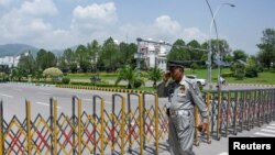 د پاکستان انتخاباتي کمېشن ته تلونکی سړک تړل شوی دی او یو سرتېری ورباندې پهره کوي - د اګست دویمې انځور.