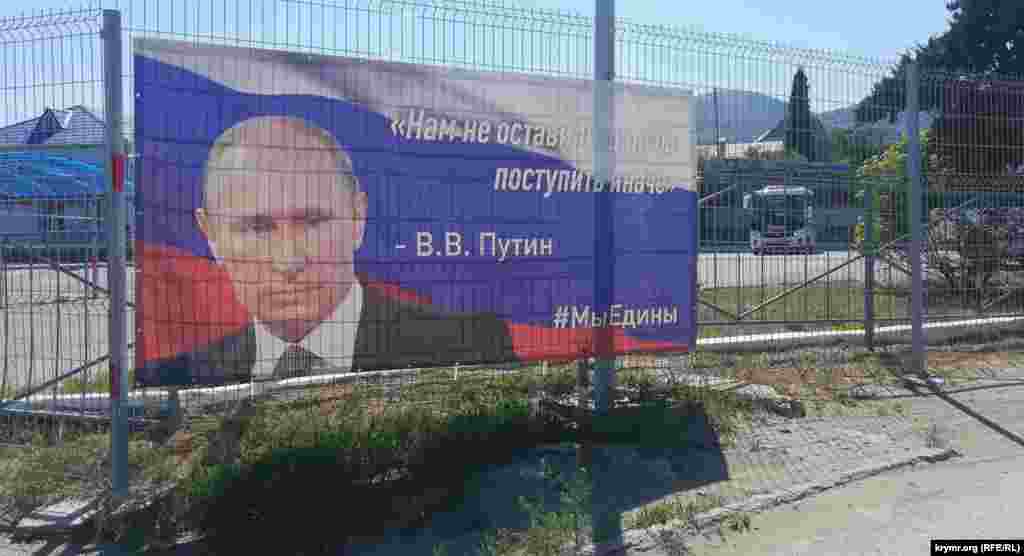 Баннер на ограждении «зоны безопасности» Судакской автостанции. В самом помещении автостанции еще два постера с портретом Путина меньших размеров и с другими его цитатами