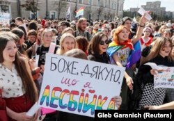 Demonstrators at the Kharkiv gay-pride march hold a sign saying Thank God I’m a Lesbian. Some 2,000 people attended the event.