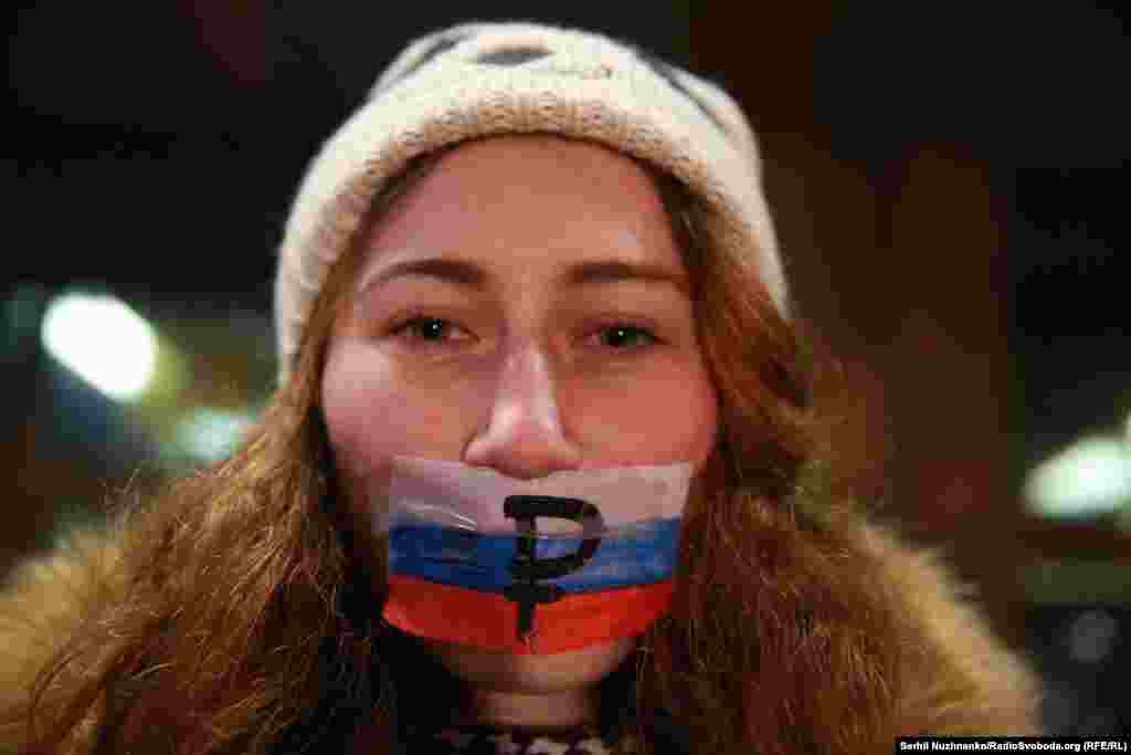 Активисты заклеивали рот российскими флагами со знаком рубля, держали «заляпанные кровью» плакаты с лозунгами, которыми сторонники упомянутых артистов и пророссийские деятели оправдывают их действия
