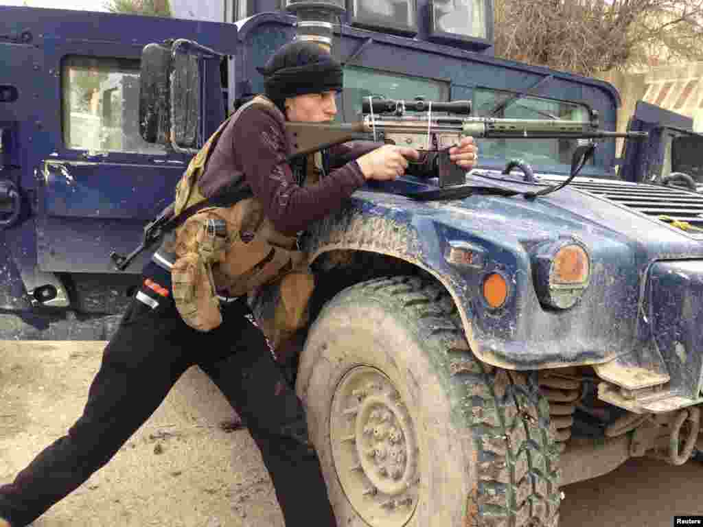 A member of the Iraqi security forces member aims his weapon during clashes with Al-Qaeda-linked jihadists in the city of Ramadi, the provincial capital of Anbar Province.
