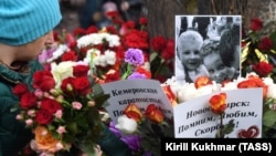 Цветы у фото погибших в сгоревшем торговом центре, Кемерово