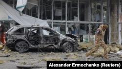 An investigator walks near a damaged store after shelling in the occupied city of Donetsk which local Russian-installed authorities called a Ukrainian military strike on January 10.