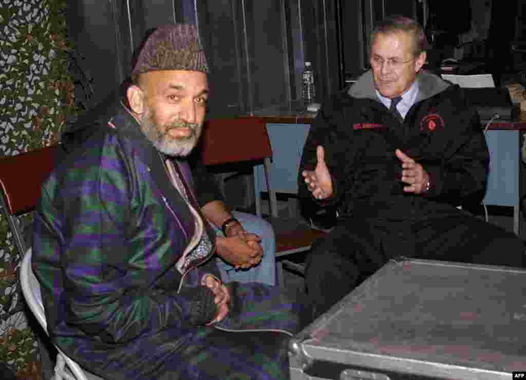 U.S. Defense Secretary Donald Rumsfeld (right) meets with Karzai at Bagram air base outside Kabul on December 16, 2001, six days before Karzai took the oath of office as chairman of the Afghan interim administration. Rumsfeld had arrived at Bagram for a surprise visit, the first by a senior U.S. official to Afghanistan since U.S.-led strikes began against the Taliban in October 2001.