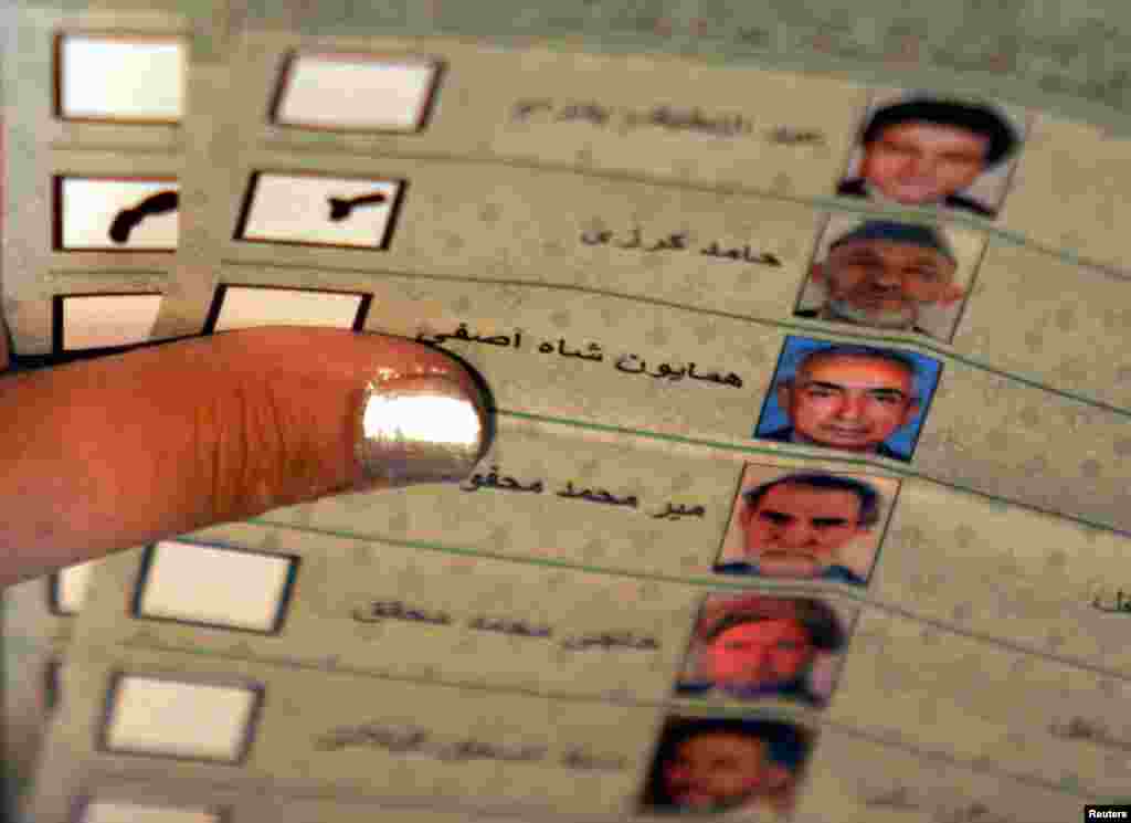 An Afghan election worker counts a vote for Karzai during the country's first post-Taliban presidential election, held on October 9, 2004. Karzai took the oath of office on December 7, 2004, for a five-year term as president.