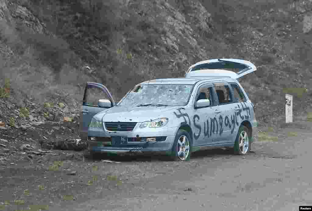 A car spray-painted with swastikas and the word "Sumqayit."  The Azerbaijani town of Sumqayit was the scene of an infamous massacre in 1988, when dozens of ethnic Armenians were killed amid unrest over Nagorno-Karabakh. 