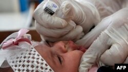 یک امدادگر سازمان ملل واکسن فلج اطفال را به کودکان در یک درمانگاه در اردوگاه آوارگان در مرکز نوار غزه میخوراند. ۹ سپتامبر ۲۰۲۰