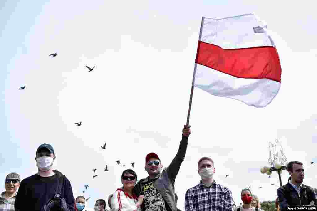 A protester waves the old Belarusian flag in Minsk during the collection of signatures.  