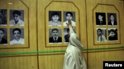 د عزېر مور په پېښور ارمي سکول کې د خپل وژل شوي ماشوم پر تصویر لاس ایښی دی. ۲۰۱۵، ۱۶م ډېسېمبر