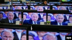TV screens showing Russian President Vladimir Putin during an annual nationwide Q&A on April 16.
