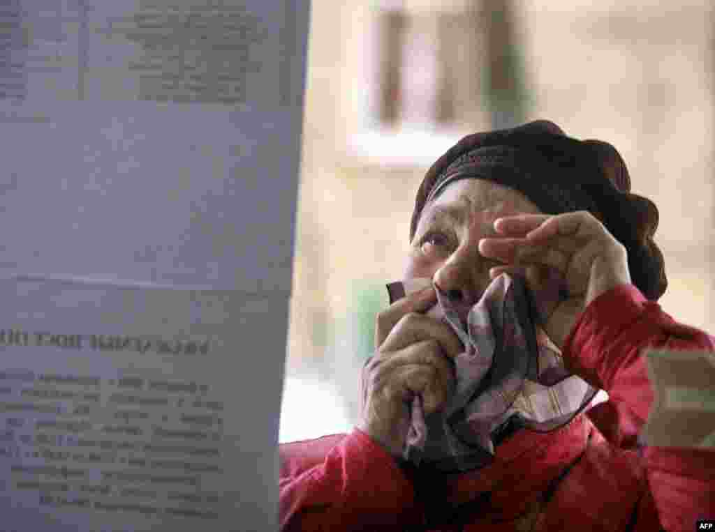 A woman cries as she reads a list of those hospitalised after the bombing outside an emergency treatment ward.