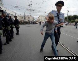 A young boy is led away by police in St. Petersburg on September 9.