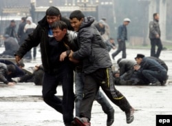 Participants in a Kyrgyz opposition rally run for cover during unrest in Bishkek in April 2010.