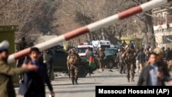 Security forces inspect the site of a suicide attack in the center of Kabul that killed scores of people on January 27.