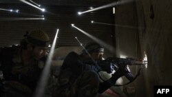 Two Syrian rebels take sniper positions in a heavily contested neighborhood of central Aleppo. Internecine strife has now been raging in the country for 3 1/2 years, killing an estimated 190,000 people.