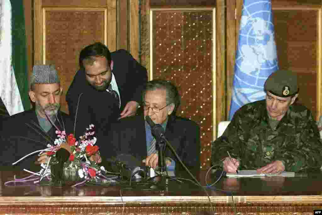 British Major General John McColl (right), UN special representative Lakhdar Brahimi (center), and Karzai during the January 4, 2002, signing of an agreement on the deployment of foreign troops on Afghan soil.