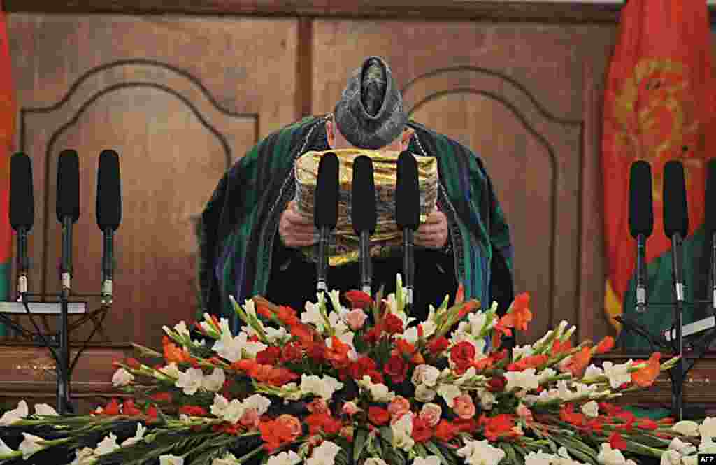 Karzai kisses a large copy of the Koran during his swearing-in as the country's president for another five years at the Presidential Palace in Kabul on November 19, 2009. A runoff vote with rival Abdullah Abdullah was canceled after Abdullah refused to participate, citing massive election fraud.