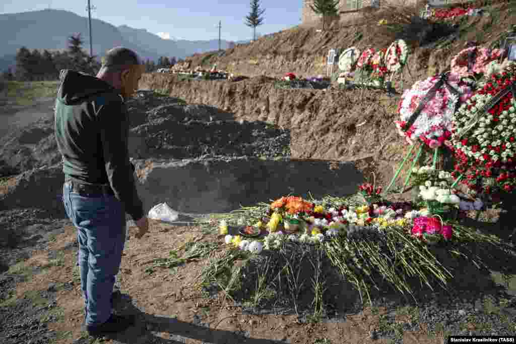 A man stands next to his son's grave in Stepanakert on November 27. The 2020 conflict officially cost the lives of 2,783 Azerbaijani servicemen and 2,425 Armenian soldiers, as has been reported thus far. 