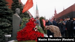 A woman bows her head to the bust of Soviet leader Josef Stalin during a ceremony marking the 66th anniversary of his death in Red Square, Moscow, on March 5.