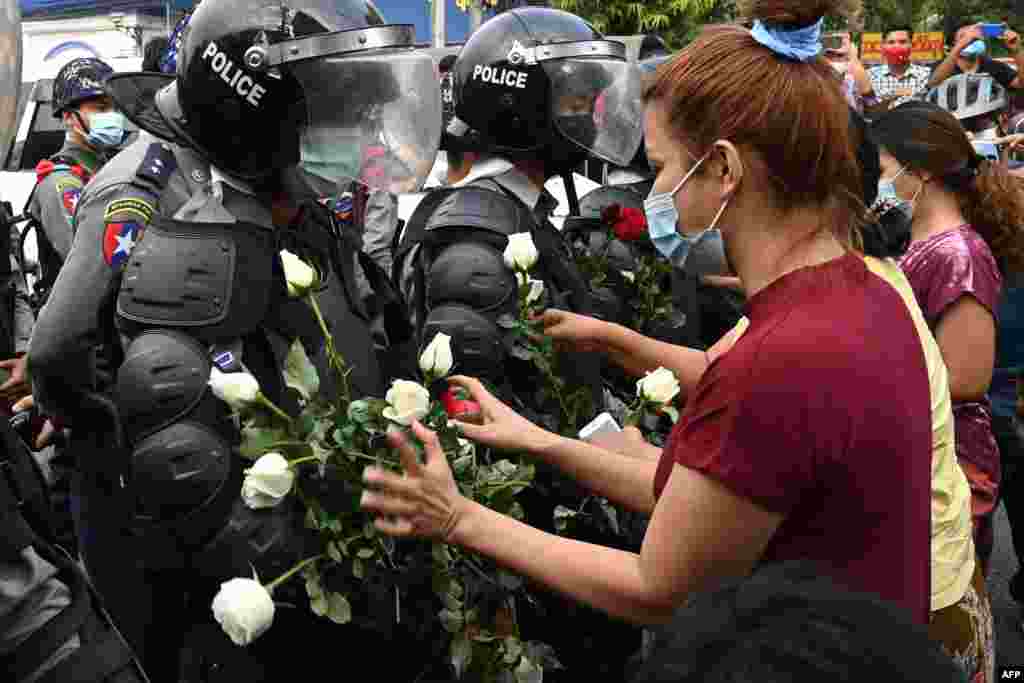 Протестующие дарят белые цветы полиции в Янгоне 6 февраля. Фотография очень напоминает сцены в Минске в начале осени 2020 года 
