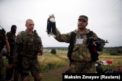 A pro-Russia separatist holds a stuffed toy found at the crash site of Malaysia Airlines flight MH17, near the settlement of Hrabove in the Donetsk region. (file photo)