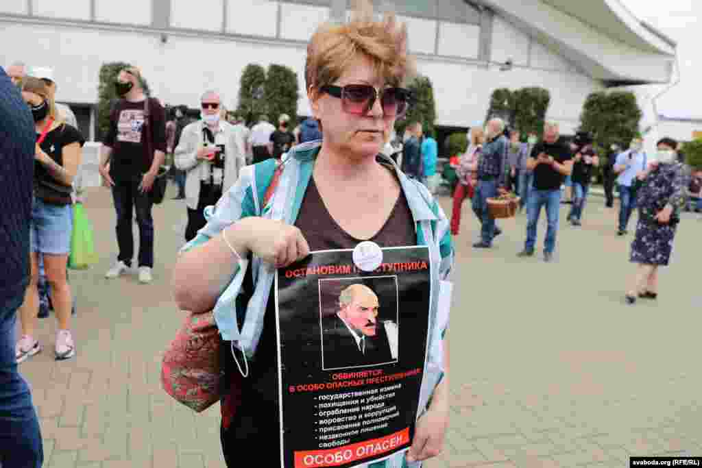 A protester at the June 7 rally in Minsk holds a portrait of Belarusian President Alyaksandr Lukashenka with a sign reading: "Stop the criminal man."  