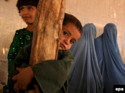 An Afghan refugee family waits outside the United Nation High Commissioner for Refugees office in Karachi.