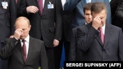 Владимир Путин (слева) и Виктор Янукович (справа) крестятся во время богослужения в Киеве, 2013 год
