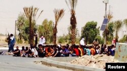 ISIL gunmen with captured police in the Iraqi city of Tikrit on June 12, 2014.