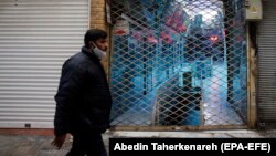 An Iranian man wearing a face mask walks past a closed shopping mall at a bazaar in Tehran earlier this year.