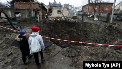 Дети смотрят на воронку после российского ракетного обстрела. Село Солонка, Львовская область, 16 ноября 2022 года