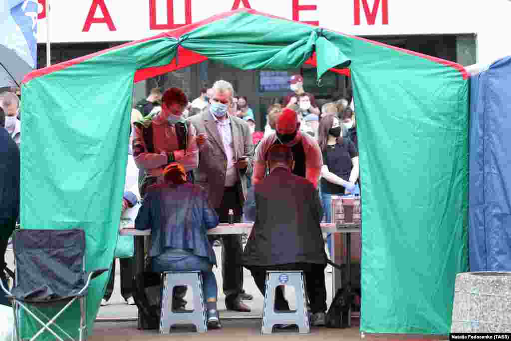 People add their signatures in support of presidential candidate Valery Tsepkalo during a rally outside Komarovka Market on June 7.  