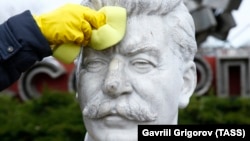A volunteer cleans a bust of Soviet leader Josef Stalin during a community work day in the Muzeon Park of Arts in Moscow on April 13.