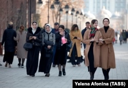Women walk down a street in the Chechen capital, Grozny. There have been reports that police have been stopping people in Chechnya and checking their phones for evidence they are subscribed to 1ADAT.