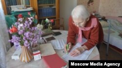 An elderly woman casts her vote from home in Moscow's municipal elections on September 10.