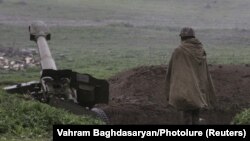 An ethnic Armenian soldier in Nagorno-Karabakh's forces stands near an artillery unit in the town of Martakert, where clashes with Azeri forces are taking place, on April 3.